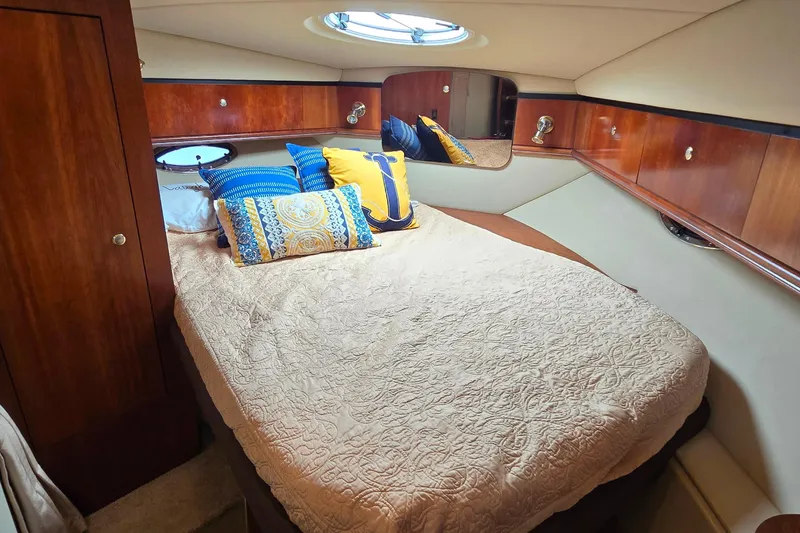 Slide: The Image of Luxurious cabin interior of 2005 Cruisers Yachts 340 Express with cozy bedding and elegant wood finish. - 19