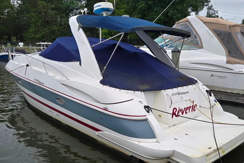 Slide: The Image of 2005 Cruisers Yachts 340 Express docked, featuring blue canopy and sleek design. - 4