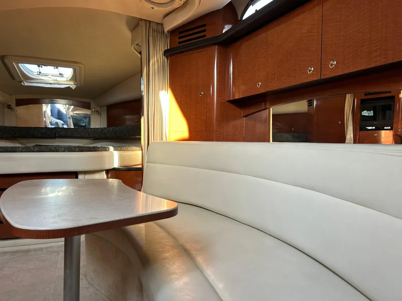 Slide: The Image of 2004 Sea Ray 340 Sundancer interior with white seating and wooden cabinetry. - 16