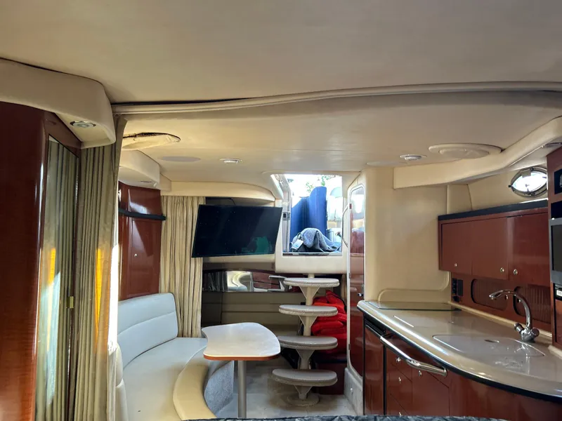 Slide: The Image of Interior of 2004 Sea Ray 340 Sundancer yacht with seating, table, and kitchenette. - 19