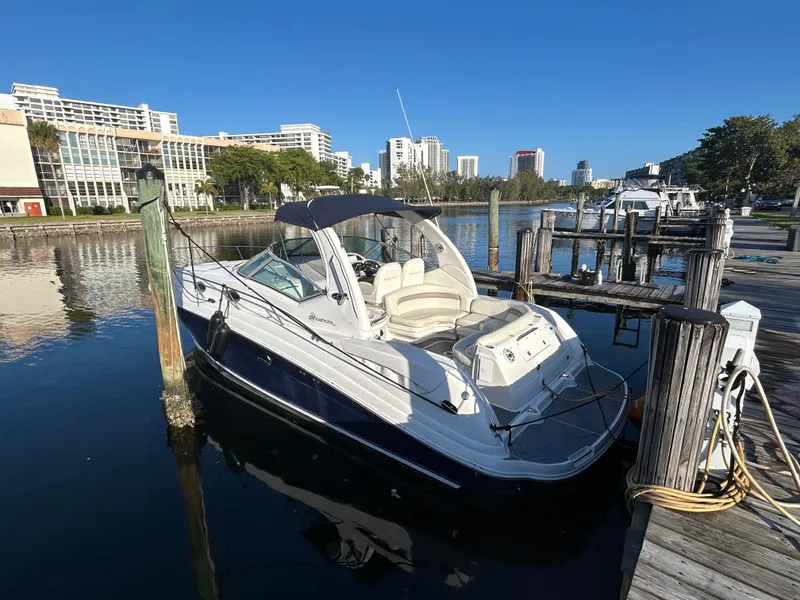 Slide: The Image of 2004 Sea Ray 340 Sundancer docked in a marina with cityscape background. - 2