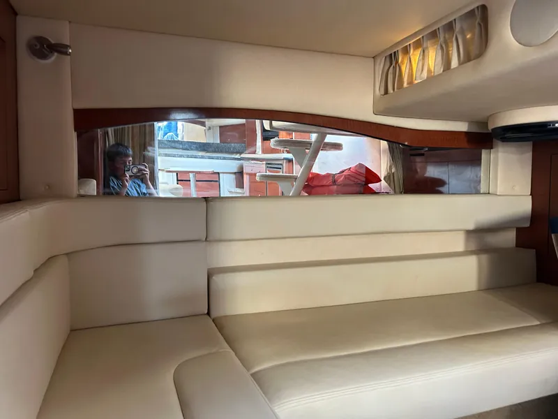 Slide: The Image of 2004 Sea Ray 340 Sundancer interior with cream leather seating and window view. - 22