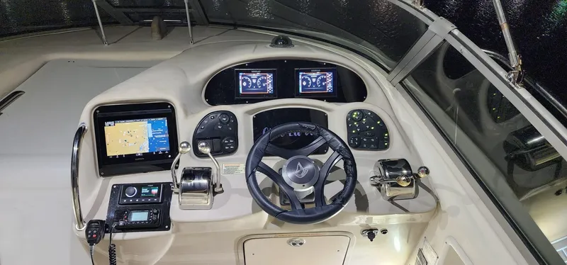 Slide: The Image of Control panel of a 2004 Sea Ray 340 Sundancer boat with navigation screens and steering wheel. - 30