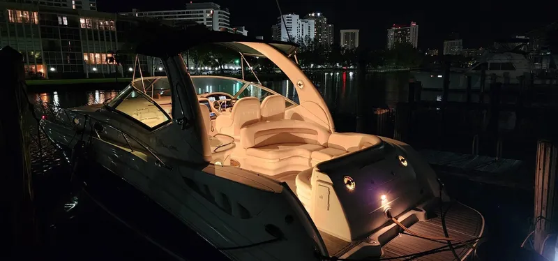 Slide: The Image of 2004 Sea Ray 340 Sundancer yacht illuminated at night in a marina setting. - 32