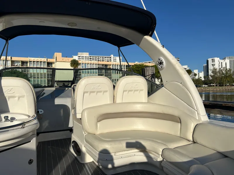 Slide: The Image of 2004 Sea Ray 340 Sundancer boat interior with white seating and cityscape background. - 8