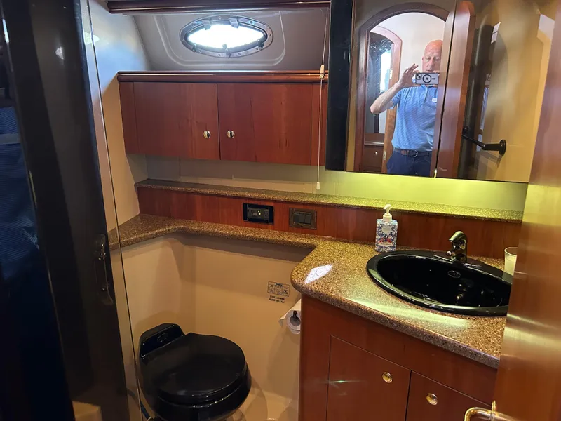 Slide: The Image of 2001 Cruisers Yachts 4450 Express Motoryacht bathroom with wood cabinetry and black sink. - 44