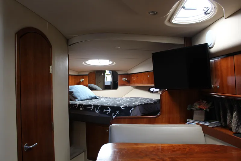 Slide: The Image of Interior of 2005 Cruisers Yachts 340 Express with bed, TV, and wooden cabinetry. - 11