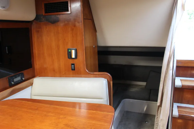 Slide: The Image of 2005 Cruisers Yachts 340 Express cabin interior with wooden table and seating. - 13