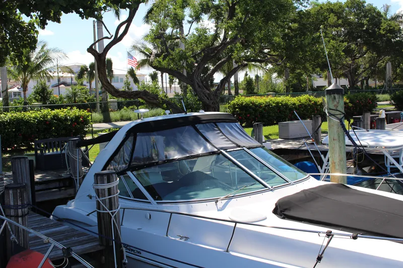 Slide: The Image of 2005 Cruisers Yachts 340 Express docked at a marina with lush greenery. - 6