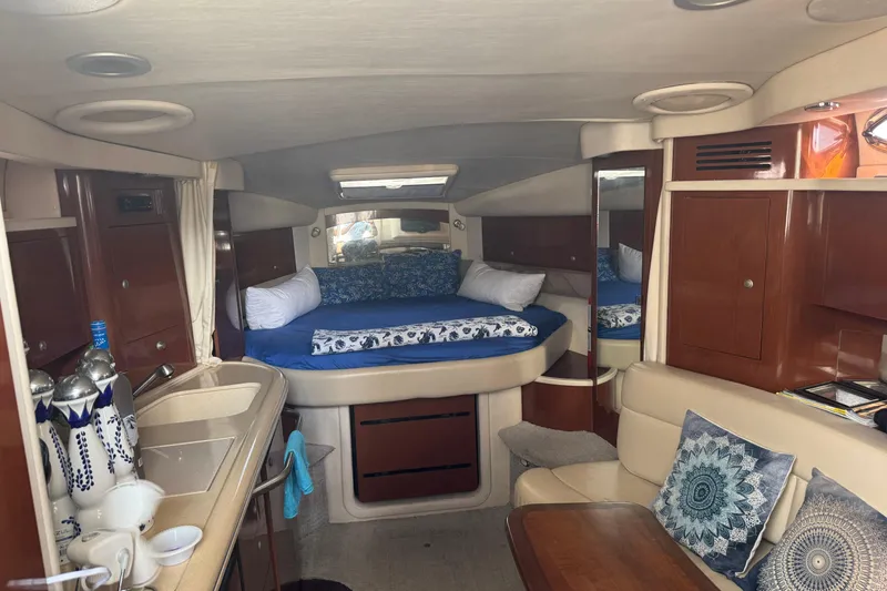 Slide: The Image of 2008 Sea Ray 340 Sundancer cabin interior with bed, kitchenette, and seating area. - 10