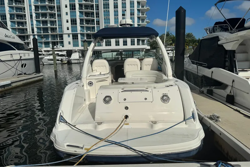 Slide: The Image of 2008 Sea Ray 340 Sundancer docked at marina with modern buildings in background. - 2