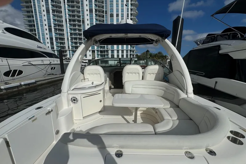 Slide: The Image of 2008 Sea Ray 340 Sundancer yacht with white seating, docked near modern buildings. - 4