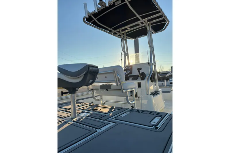Slide: The Image of 2026 Excel 220 Bay Pro Elite boat interior with seating and console, under a clear sky. - 11