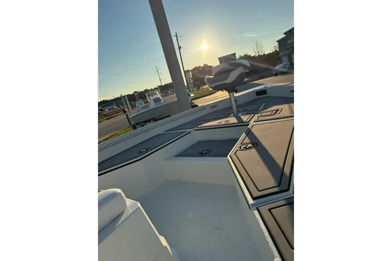Slide: The Image of 2026 Excel 220 Bay Pro Elite boat deck at sunset, showcasing seating and storage compartments. - 12
