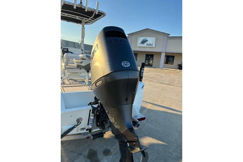 Slide: The Image of 2026 Excel 220 Bay Pro Elite boat with Suzuki outboard motor in parking lot. - 13