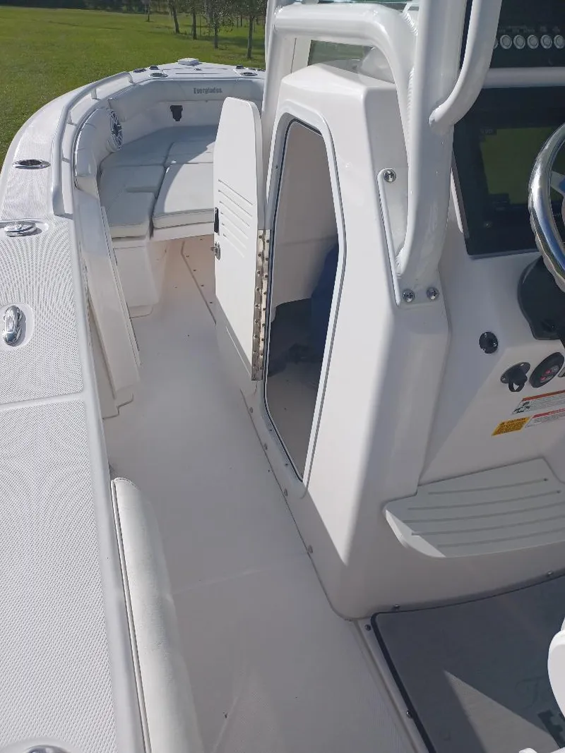 Slide: The Image of 2022 Everglades 243 Center Console boat interior with sleek white design and modern controls. - 14
