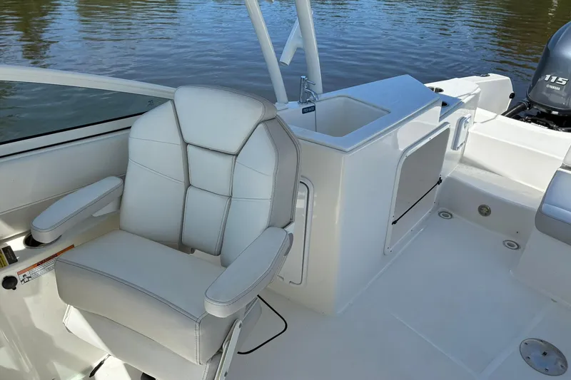 Slide: The Image of 2025 World Cat 230 SD boat interior with white seating and storage area. - 11