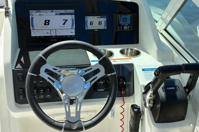 Slide: The Image of Steering console of 2025 World Cat 230 SD boat with digital displays and controls. - 12