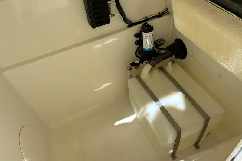 Slide: The Image of Interior view of 2025 World Cat 230 SD boat showing water tank and pump system. - 15