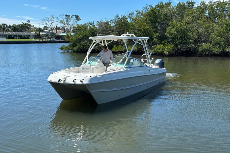 Slide: The Image of 2025 World Cat 230 SD boat cruising on a calm river with lush greenery. - 3