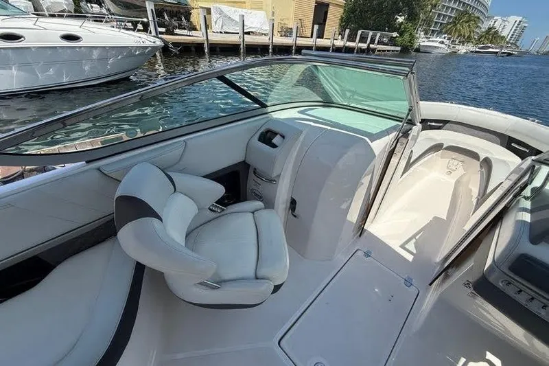 Slide: The Image of 2014 Regal 2500 Bowrider interior with white seating, docked by waterfront. - 4