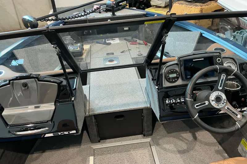 Slide: The Image of Interior view of a 2026 Starweld 16 SXT boat cockpit with steering wheel and controls. - 12