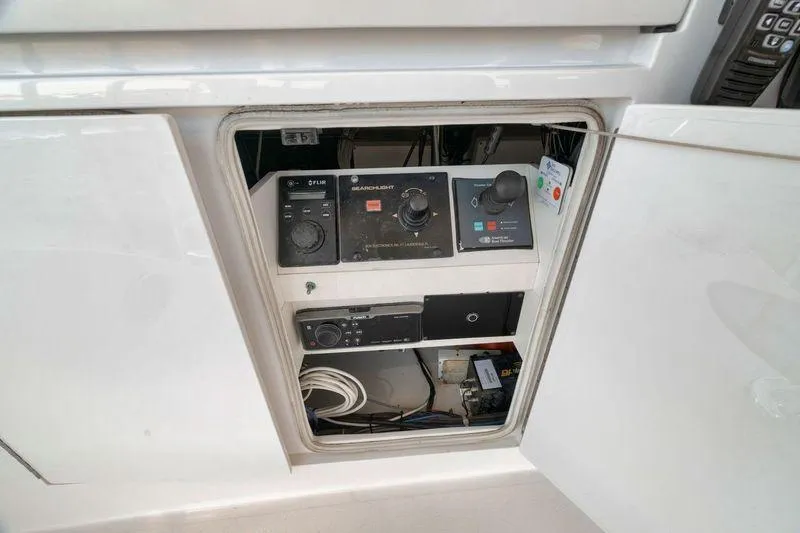 Slide: The Image of Control panel inside a 2009 Hatteras 60GT yacht, featuring various electronic components. - 33