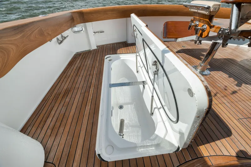 Slide: The Image of 2009 Hatteras 60GT yacht deck with open storage compartment and wooden flooring. - 41