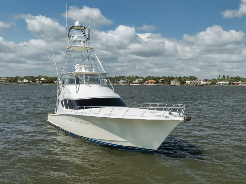 Slide: The Image of 2009 Hatteras 60GT yacht on calm water under a partly cloudy sky. - 5