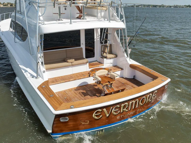 Slide: The Image of 2009 Hatteras 60GT yacht "Evermore" cruising on open water, featuring a spacious deck. - 6