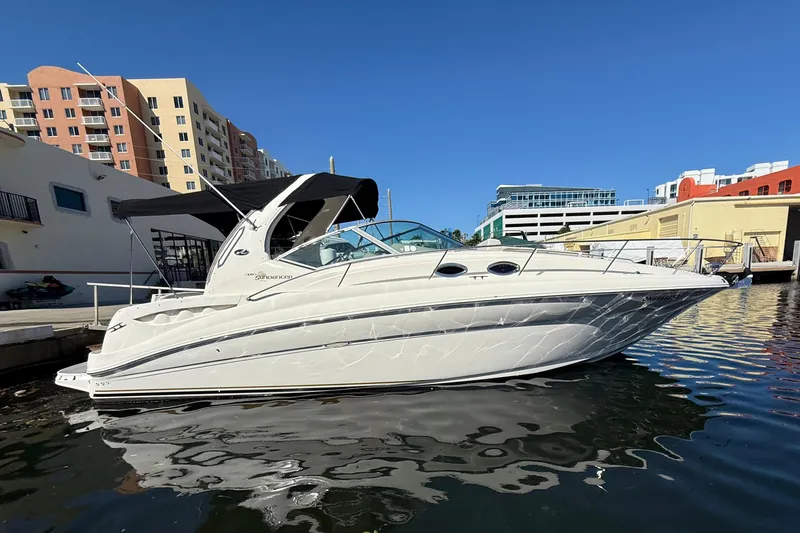 Slide: The Image of 2003 Sea Ray 320 Sundancer boat docked in urban marina setting. - 1