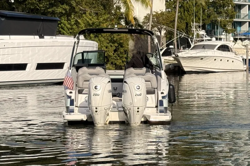 Slide: The Image of 2024 Regal LX9 boat with twin Yamaha 200 engines docked in a marina. - 4