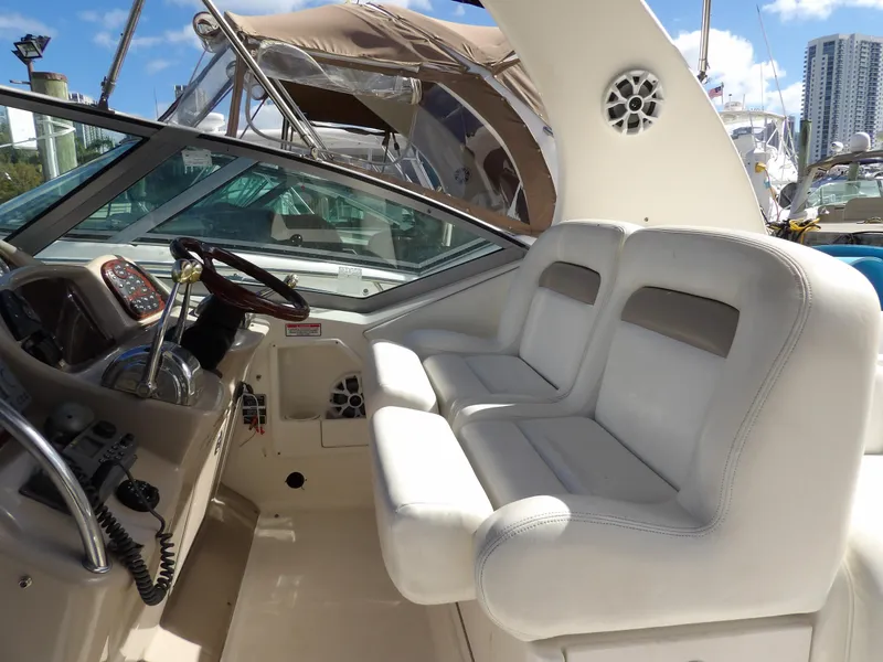 Slide: The Image of 2004 Sea Ray 320 Sundancer cockpit with white seating and steering wheel. - 16