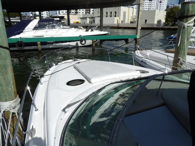 Slide: The Image of 2004 Sea Ray 320 Sundancer docked at marina, surrounded by other boats. - 2