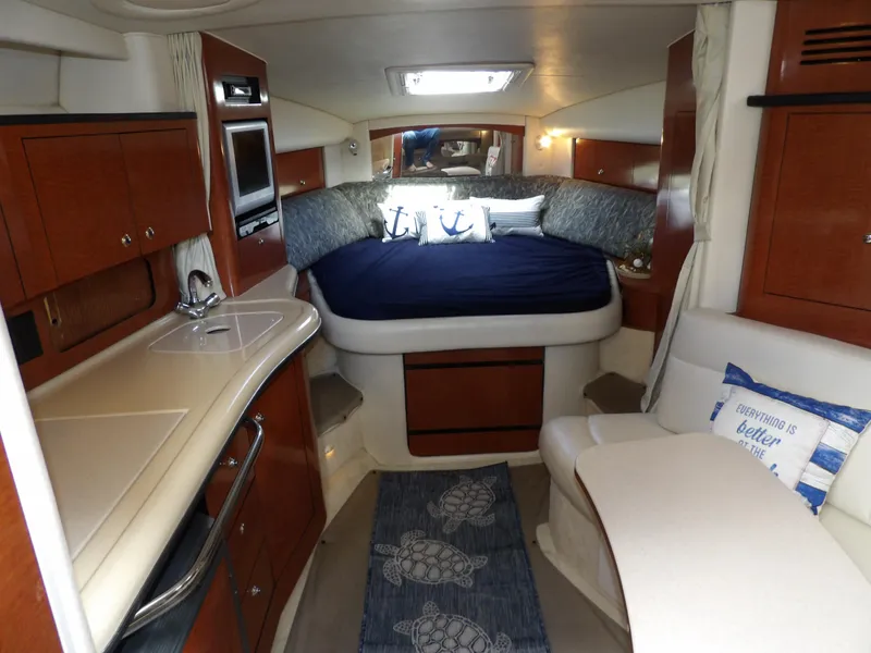 Slide: The Image of Luxurious 2004 Sea Ray 320 Sundancer cabin interior with cozy bed and kitchenette. - 35