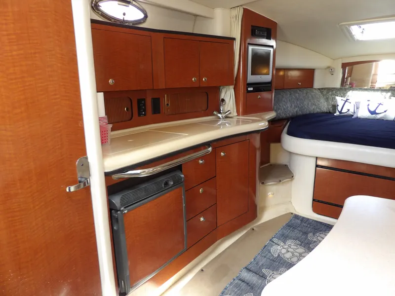 Slide: The Image of Interior of 2004 Sea Ray 320 Sundancer with kitchenette and cozy sleeping area. - 36