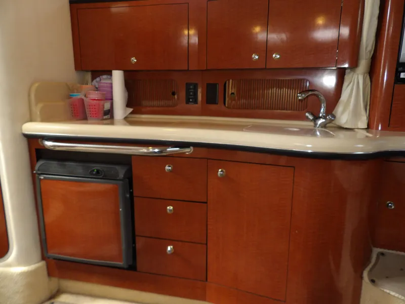 Slide: The Image of 2004 Sea Ray 320 Sundancer kitchen with wood cabinets and compact appliances. - 39