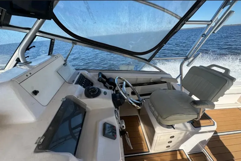 Slide: The Image of 2003 Grady-White Marlin 300 boat interior with helm, steering wheel, and ocean view. - 11