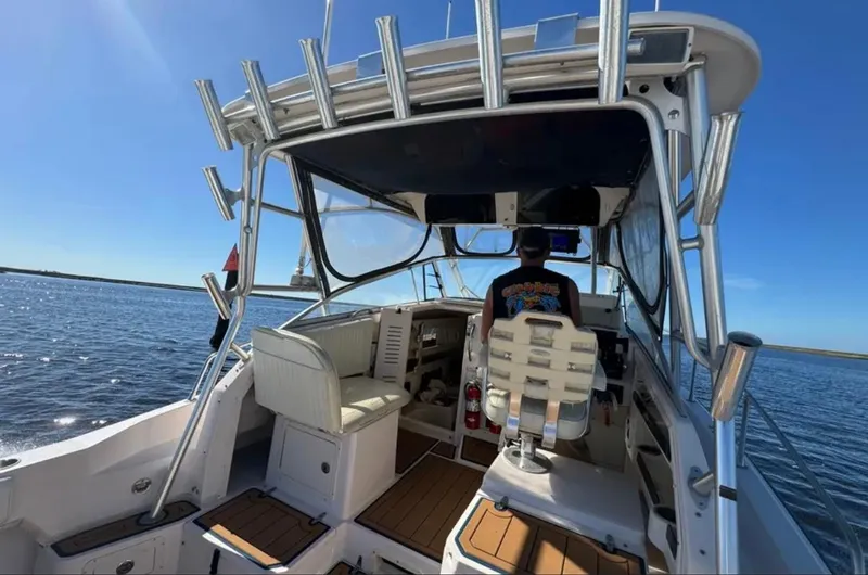 Slide: The Image of 2003 Grady-White Marlin 300 boat interior with captain at helm on open water. - 16