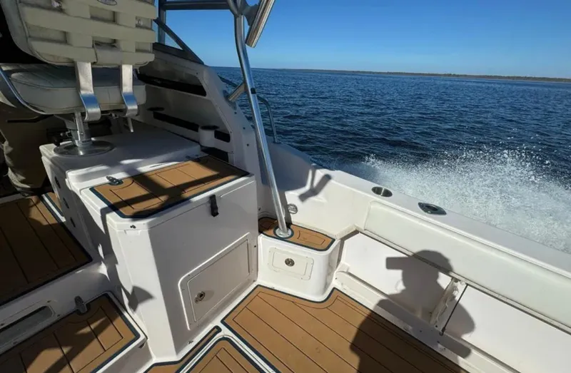 Slide: The Image of 2003 Grady-White Marlin 300 boat interior with teak flooring, cruising on open water. - 18