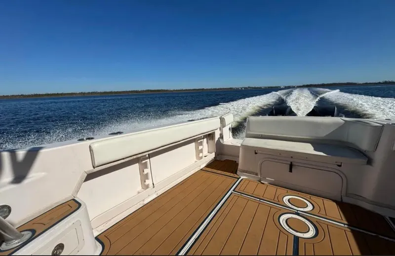 Slide: The Image of 2003 Grady-White Marlin 300 boat cruising on open water, showcasing spacious deck and seating. - 26