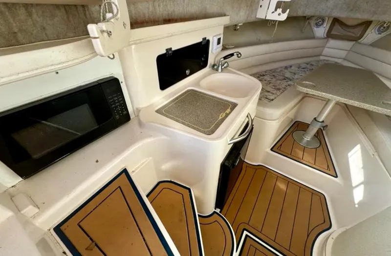 Slide: The Image of 2003 Grady-White Marlin 300 cabin interior with kitchenette, sink, and seating area. - 29