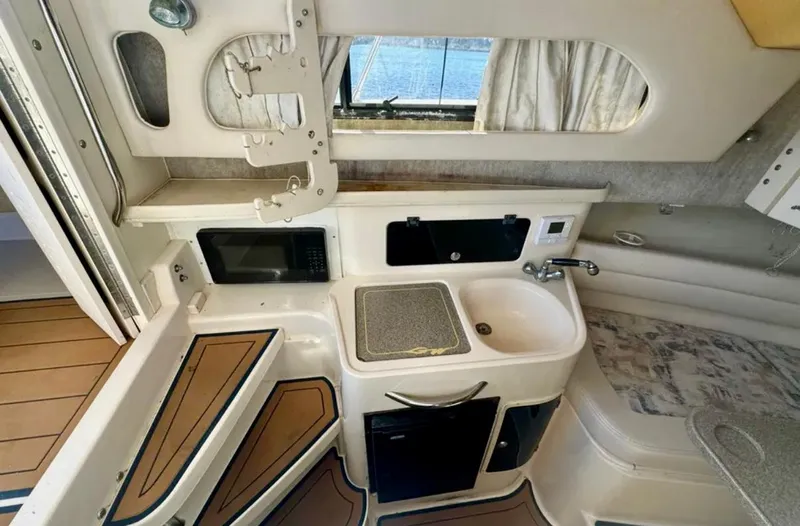 Slide: The Image of 2003 Grady-White Marlin 300 cabin interior with kitchenette, sink, and seating area. - 31