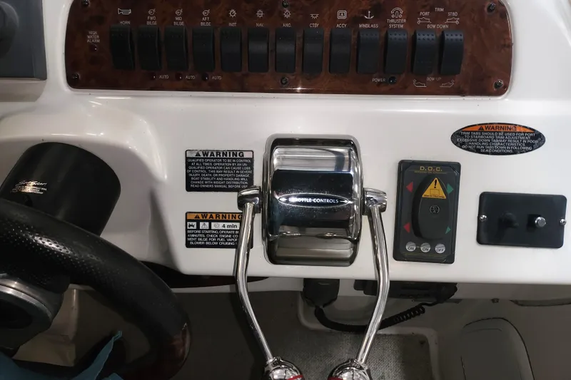 Slide: The Image of Control panel of a 2004 Meridian 411 Sedan boat with throttle and warning labels. - 12