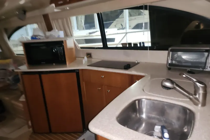 Slide: The Image of Interior of 2004 Meridian 411 Sedan yacht kitchen with sink, microwave, and cabinets. - 28
