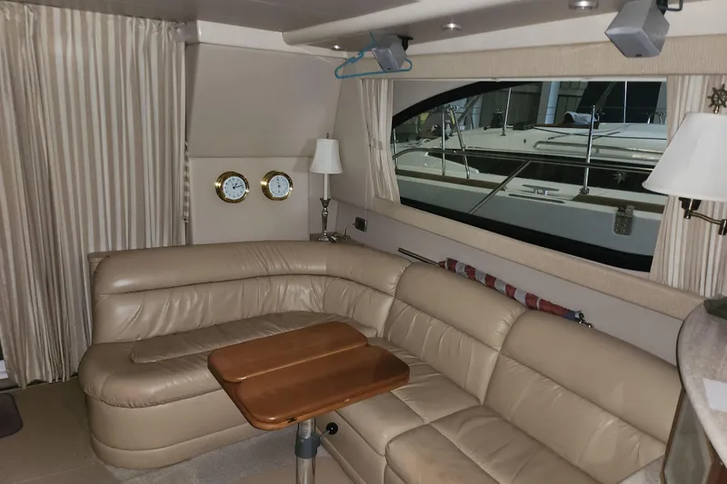 Slide: The Image of Luxurious interior of 2004 Meridian 411 Sedan yacht with leather seating and wooden table. - 34