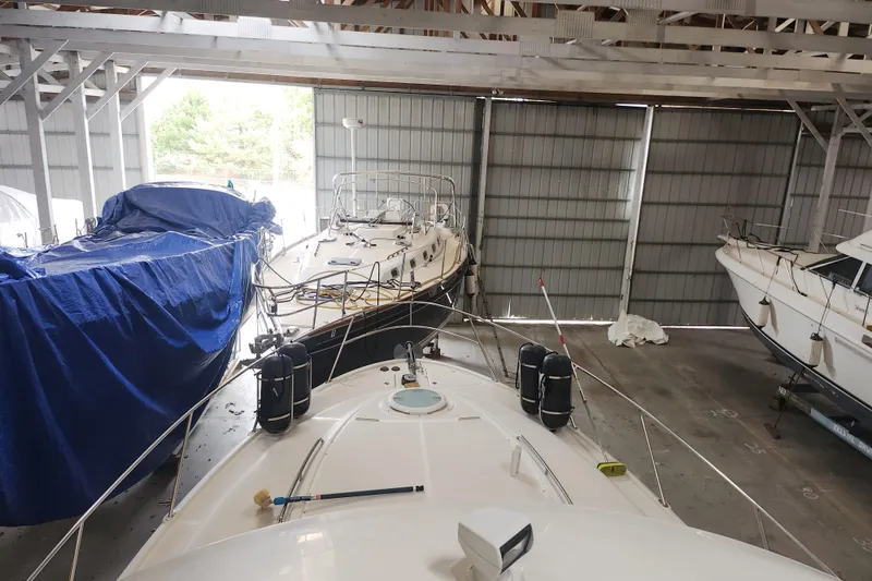 Slide: The Image of 2004 Meridian 411 Sedan yacht in storage, surrounded by other boats in a covered facility. - 6