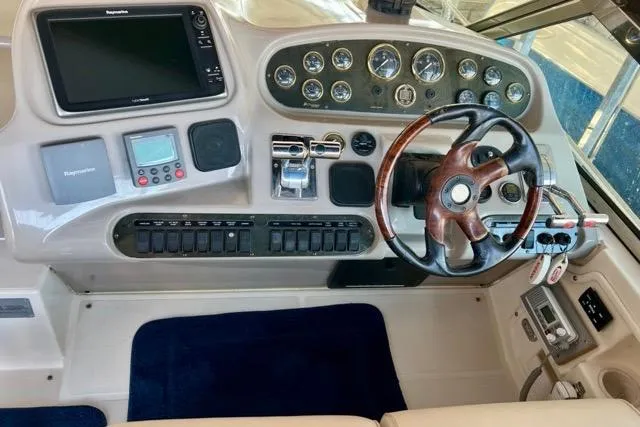 Slide: The Image of 2003 Cruisers Yachts 3772 Express helm with gauges, controls, and wooden steering wheel. - 14