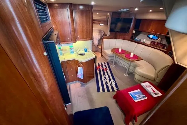 Slide: The Image of Luxurious 2003 Cruisers Yachts 3772 Express cabin interior with cozy seating and kitchenette. - 17