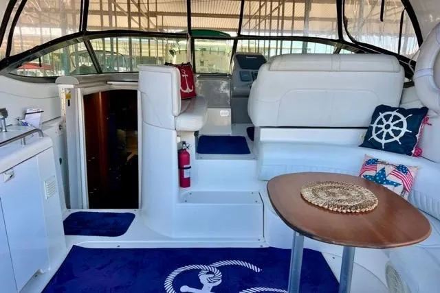 Slide: The Image of 2003 Cruisers Yachts 3772 Express interior with white seating, nautical decor, and wooden table. - 9